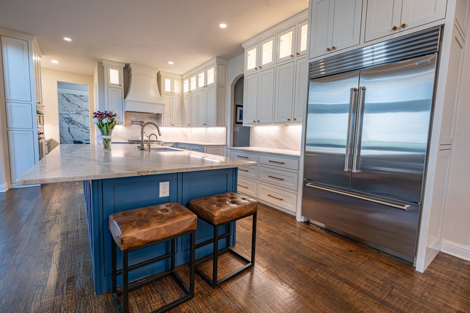 Kitchen with marble countertops, a center island and stainless steel appliances.